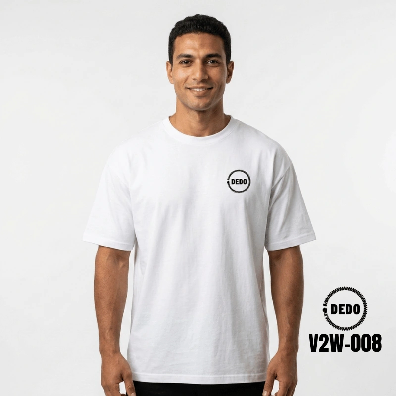 Rear view of a smiling man looking over his shoulder on a sunny waterfront promenade with feluccas in the background, wearing a white oversized t-shirt with a highly detailed, black cybernetic skull graphic print on the back integrated with circuit board wiring and mechanical details. The DEDO logo and product code V2W-008 are visible in the lower corner.
